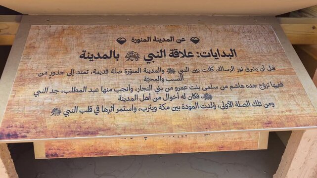 A person flipping through wooden display panels with Arabic text on Medina's history.