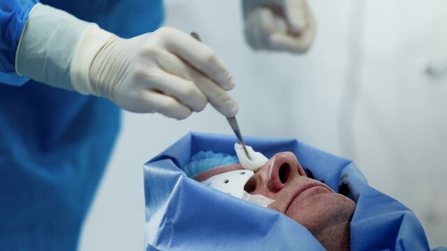 Eye surgery patient receives preoperative preparation from a healthcare professional in a hospital. Concept ophthalmology, surgery and patient care.
