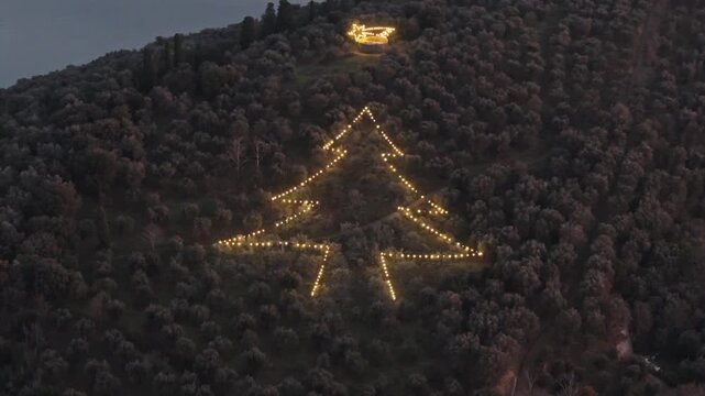 Aerial view of giant Christmas tree installation on a hillside in Tuoro sul Trasimeno, Umbria, Italy.