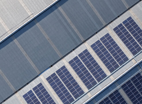 Aerial view of solar panels installed on the corrugated metal roof of an industrial factory building in Kilsyth South, Melbourne, VIC, Australia.