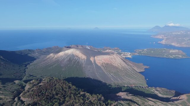 Aerial view of the volcanic crater and rugged landscape of Vulcano island surrounded by the deep blue Mediterranean Sea in Lipari, Sicily, Italy.