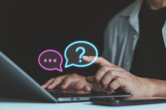 Business professional using a laptop with glowing question mark icons, illustrating online questions, customer support, problem solving, digital communication, uncertainty, and information search.