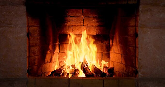 The fire is burning in the stone fireplace. Super slow motion