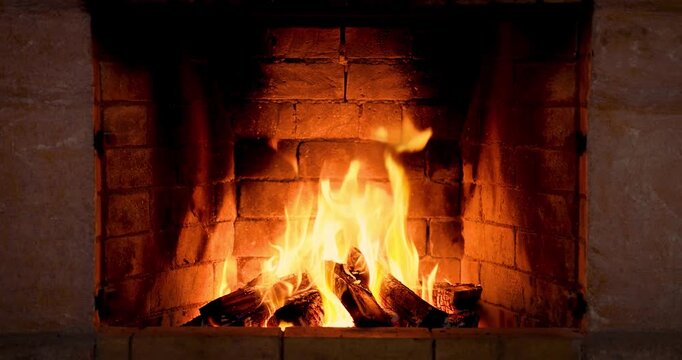 The fire is burning in the stone fireplace. Super slow motion, dolly shot