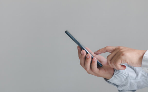 Close up hand of businessman using mobile smart phone isolated on a white background. Searching data networks or chatting online. Typing and sending a message. mockup mobile phone wireless technology.