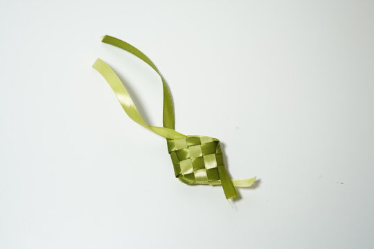green woven ribbon ketupat ornament isolated on white background