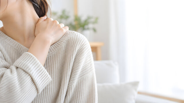 白いニットを着た女性が肩に手を添えるリラックスイメージ