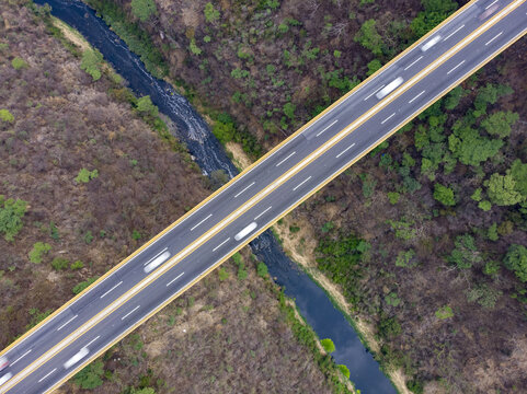 Aerial view of the Autopista Mexico - Guadalajara highway bridge crossing over a river and dense forest in Ecuandureo, Michoacan, Mexico.
