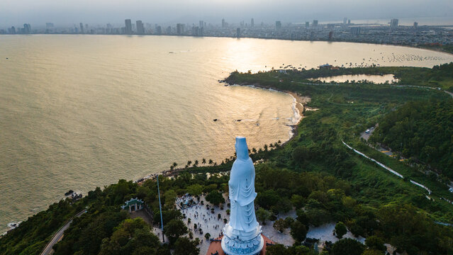 Aerial view of the Lady Buddha statue at Linh Ung Pagoda overlooking the coastline and city skyline in Da Nang, Vietnam.