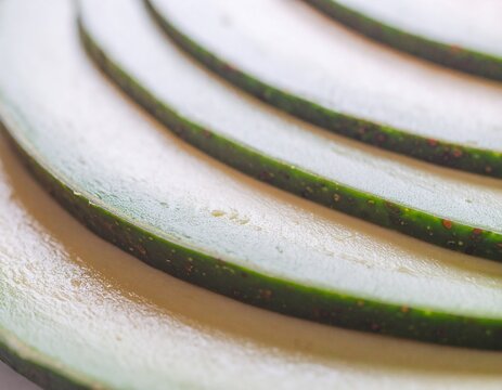 Macro close-up of fresh ripe avocado slices with green skin.