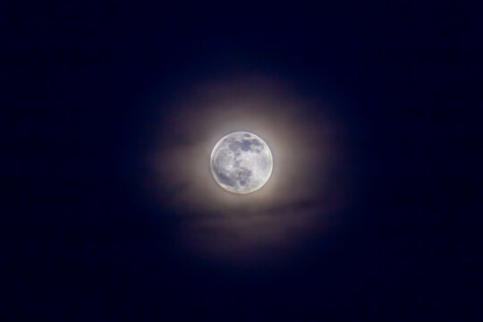 Full moon in the night sky with clouds