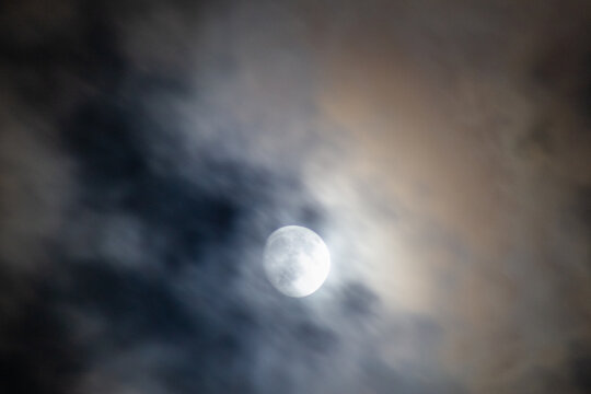 Full moon in the night sky with clouds