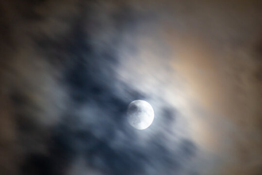 Full moon in the night sky with clouds