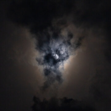 Full moon in the night sky with clouds