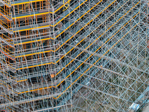 Aerial view of the Helmholtz-Zentrum Berlin Science Campus building under construction, featuring extensive metal scaffolding and yellow platforms in Berlin, Berlin, Germany.