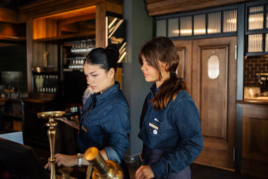 Young adult waitresses working at restaurant and cafe bar service counter