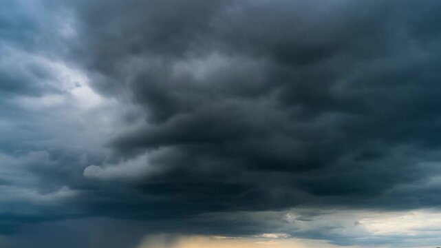 Heavy dark grey storm clouds rolling in the overcast sky with rain