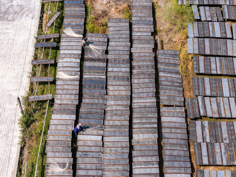 Aerial view of workers spreading sohun glass noodles on drying racks at the UKM Sohun production facility in Kecamatan Tulung, Jawa Tengah, Indonesia.