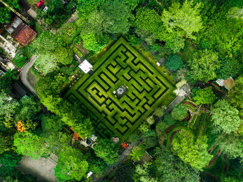 Aerial view of the hedge maze at Coban Rondo Waterfall Pujon surrounded by lush green trees and vegetation in Kecamatan Pujon, Jawa Timur, Indonesia.
