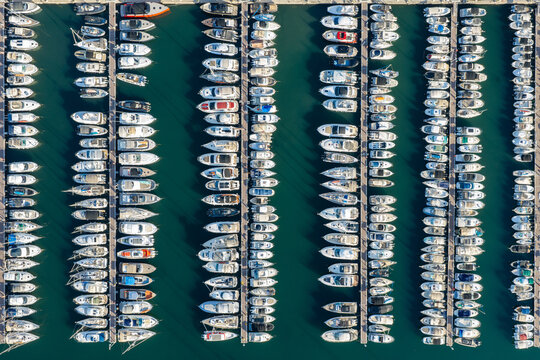 Aerial view of the marina in Antibes with numerous yachts and boats docked in neat rows on the turquoise water of the Mediterranean Sea in Antibes, Provence-Alpes-Cote d'Azur, France.