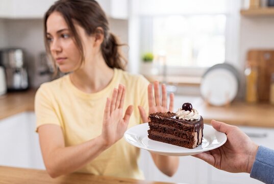 Woman Rejecting Chocolate Cake with Stop Gesture for Diet and Health