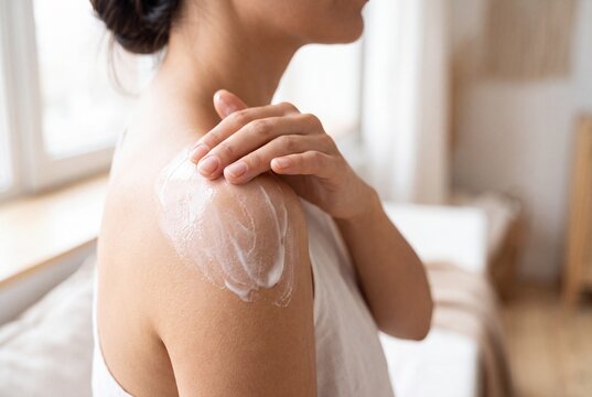 Woman Applying Moisturizing Body Lotion on Her Shoulder for Daily Skincare