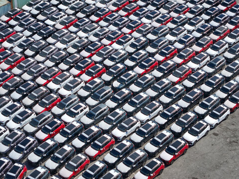 Aerial view of rows of new cars parked in a large logistics terminal in Vado Ligure, Liguria, Italy.