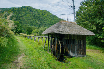 日本の田舎の茅葺き屋根の水車小屋と水路と山の風景-福島県南会津町　前沢曲家集落 © KATO Japan Trip