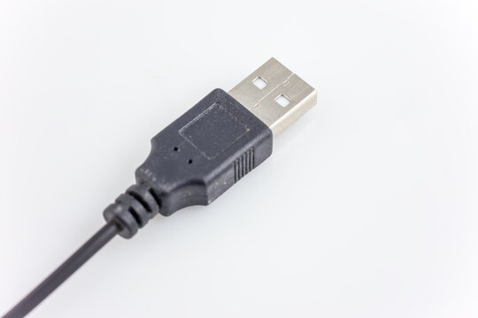 A close-up shot of a standard USB Type A male connector, featuring a black plastic housing and metal contact pins, attached to a black cable, isolated on a white background.