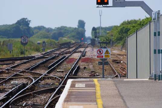 Technical view of railway junction tracks with signals and safety signs.
