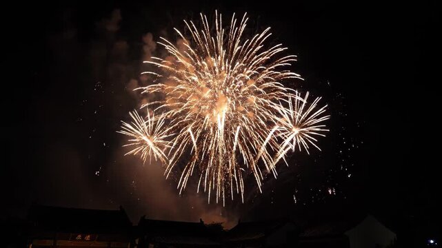 Brilliant fireworks blooming in the night sky, ancient city night sky fireworks show