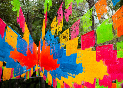 Colorful paper decorations (Papel Picado) hanging in the streets of Mexico City during the Day of the Dead (Dia de Muertos) festivities.