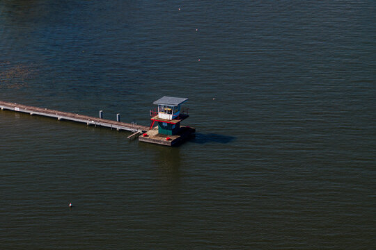 Aerial view of the Berlin-Grunau Regatta Course featuring a small judge's tower on a platform connected by a long pier in the river in Berlin, Berlin, Germany.
