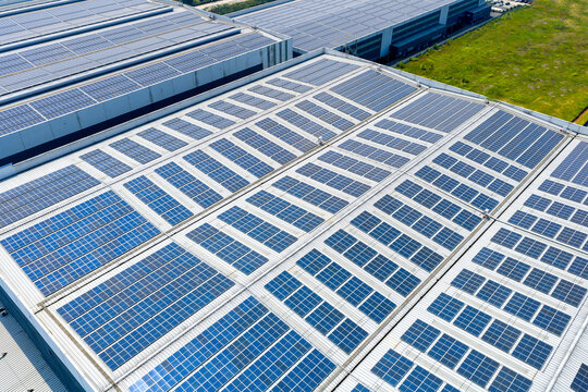 Aerial view of large factory roof solar photovoltaic panel array