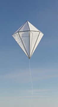 Diamond kite flying high in clear blue sky.