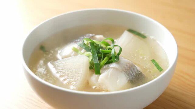 Fresh fish soup in a white bowl, light cod and radish soup