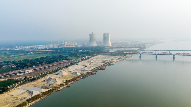 Aerial view of the Rooppur Nuclear Power Plant with its cooling towers, the Padma River, and the historic Hardinge Bridge in the background in Pabna, Rajshahi Division, Bangladesh.