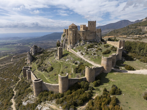 Aerial view of Loarre Castle, a historic Romanesque fortress with stone walls and towers, situated on a rocky hill in the countryside, Loarre, Aragon, Spain.