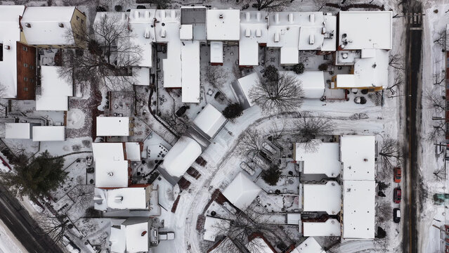 Aerial view of Lancaster city streets and rooftops covered in a thick blanket of fresh white snow, with bare trees and quiet roads in Lancaster, Pennsylvania, United States.