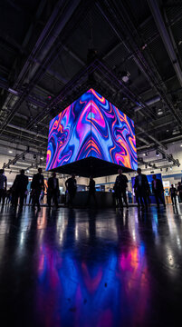 Large LED cube screen glowing at trade show convention center