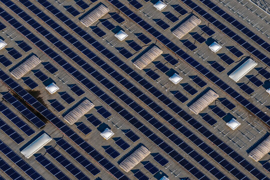 Aerial view of solar panels installed on a large industrial roof with skylights in Nera Montoro, Umbria, Italy.