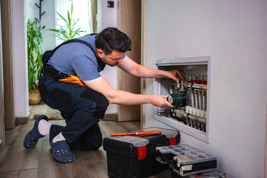 Technician installing underfloor heating system at home