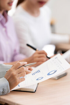 Close Up Businesspeople Writing Notes and Analyzing Financial Data in Vertical Framing