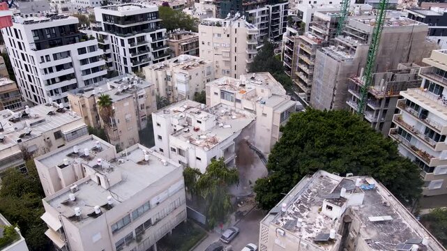 Aerial view of a building being demolished in a city during the day, motion footage.