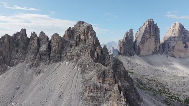 Rugged limestone peaks of Tre Cime di Lavaredo in Italian Dolomites aerial landscape cinematic shot.