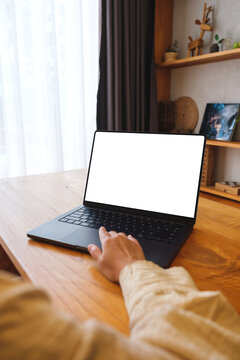 Vertical mockup image of a woman working on laptop computer with blank screen at home
