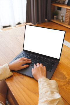 Vertical mockup image of a woman working on laptop computer with blank screen at home