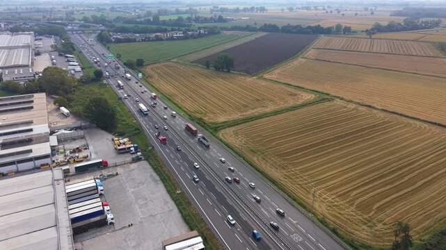 Aerial view of a busy highway and industrial area with fields on the side