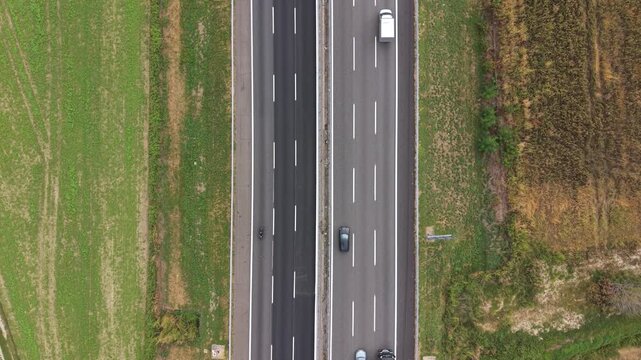 Aerial View of Highway: An aerial perspective showcases a modern highway cutting through a green landscape, with vehicles traversing the asphalt arteries, connecting distant destinations.