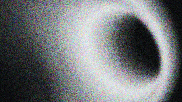 Illuminated circular halo ring, dark void core, coarse speckled grainy noise filter, smooth ethereal ambient gradient background space